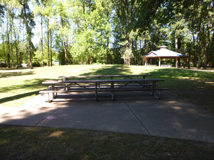 Two picnic tables on concrete slab – covered picnic area nearby
